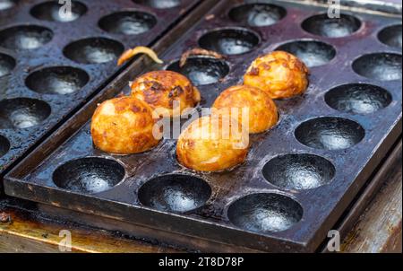 Gros plan de Takoyaki, boules de poulpe sur Hot Pan Banque D'Images