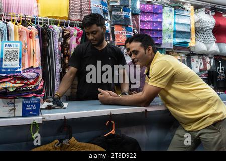 Guwahati, Assam, Inde. 19 novembre 2023. Les commerçants regardent le match de finale international d'une journée de la coupe du monde de cricket masculin ICC 2023 entre l'Inde et l'Australie, sur un téléphone portable, le 19 novembre 2023 à Guwahati, Assam, Inde. L'Australie a battu l'Inde par 6 guichets 42 balles à gauche. Crédit : David Talukdar/Alamy Live News crédit : David Talukdar/Alamy Live News Banque D'Images