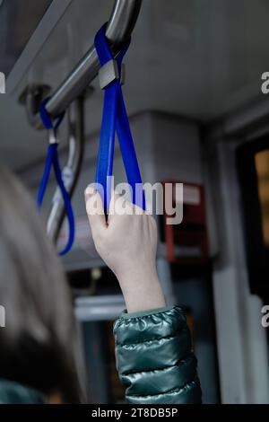 Femme tenant main courante dans un bus Banque D'Images