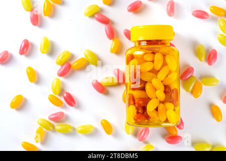 Vitamines Gummy et supplément pour adultes. La femme mange des micro-éléments de bonbons multivitaminés de gelée sucrée à partir de bouteilles de pilules transparentes, de médicaments modernes et Banque D'Images