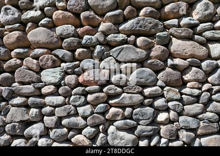 Mur rustique robuste construit à partir de diverses pierres. Fond de texture de mur de pierre Banque D'Images