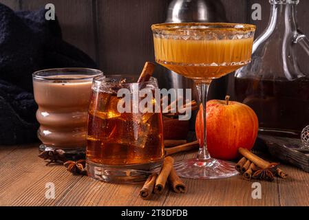 Cocktails automnaux au sirop d'érable. Alcool fort boozy, boissons mocktail non alcoolisées avec cidre de pomme, liqueur et épices, sur fond en bois foncé copie Banque D'Images