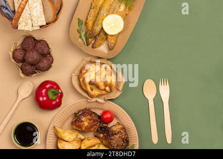 Nourriture pique-nique dans des plats jetables en carton respectueux de l'environnement. Fond marron et vert. Pose à plat Banque D'Images