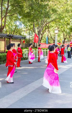 Femmes d'âge moyen dansant en costume sur la place de Pékin, Chine Banque D'Images