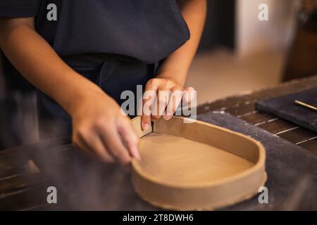 Mains de fille travaille avec de l'argile dans un atelier de poterie moderne. Le pr Banque D'Images