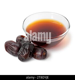 Bol en verre avec vinaigre de date et dates séchées à l'avant isolé sur fond blanc Banque D'Images