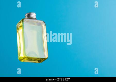 Bouteille en verre de produit de beauté avec espace de copie sur fond bleu Banque D'Images