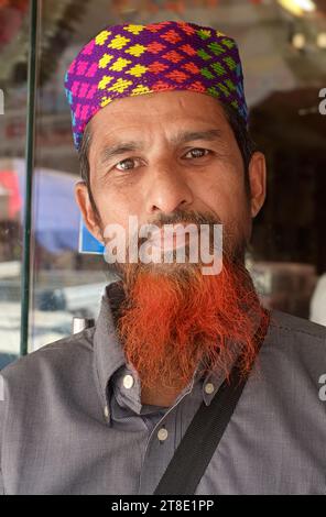 Portrait d'un jeune musulman à Mumbai, en Inde, avec une casquette colorée et une barbe rouge teintée au henné. Banque D'Images