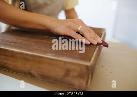 Photo en gros plan, artisan ponçant une surface en bois Banque D'Images