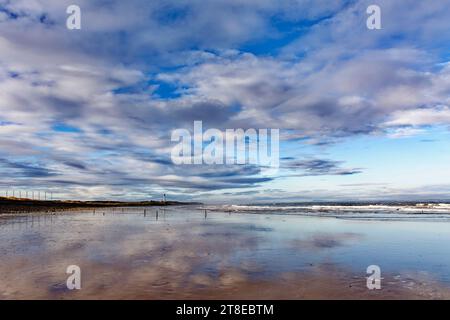 Lossiemouth Moray Coast Ecosse la plage ouest un ciel et une mer de novembre et des reflets dans le sable Banque D'Images