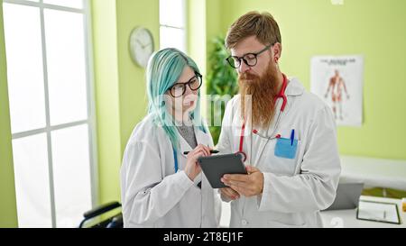 Homme et femme médecins utilisant le touchpad travaillant à la clinique Banque D'Images