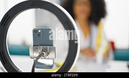 Femme afro-américaine traumatologue médecin enregistrant vidéo tutoriel du genou à la clinique Banque D'Images