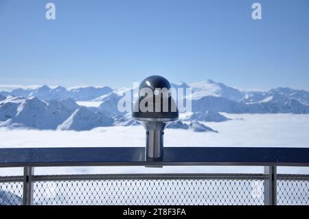 Jumelle de télescope de paysage pointée vers les montagnes. Alpes enneigées en hiver Banque D'Images