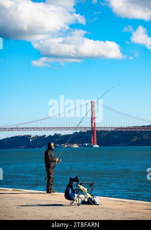 Pêcheur avec canne à pêche sur le remblai à Lisbonne, Portugal Banque D'Images