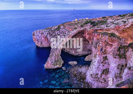 La grotte bleue de mer à l'aube à Malte, grotte de référence dans la côte sud-est de l'île dans la mer Méditerranée. Banque D'Images