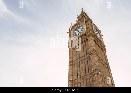 Une vue dégagée sur la tour de l'horloge historique Big Ben, debout sur un ciel nuageux léger en toile de fond à Londres, offrant une sensation de lieu et de temps. Banque D'Images
