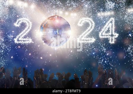 Fête disco du nouvel an 2024 dans une boîte de nuit. Boule disco lanterne à chiffres brillants. Groupe d'amis dansant et célébrant les vacances d'hiver. Banque D'Images