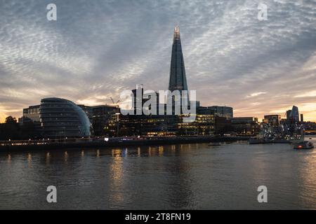 Les gratte-ciel de Londres au crépuscule, avec The Shard et l'hôtel de ville le long de la Tamise sous un motif de nuages époustouflant. Banque D'Images