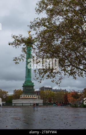 Paris, France, 2023. Place de la Bastille, la colonne de juillet et son Génie de la liberté doré, avec des bâtiments haussmanniens en arrière-plan (vertical) Banque D'Images