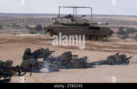 Des soldats d'infanterie israéliens de la 55e Brigade de parachutistes avec des armes légères alors qu'ils s'entraînent dans un exercice de tir réel à l'extérieur de la base de Tze'elim dans le sud d'Israël près de la frontière de la bande de Gaza le 20 novembre 2023, avec des chars Merkava du corps blindé. Les soldats sont tous des troupes de réserve de Tsahal et ne sont pas encore allés dans la bande de Gaza. Certains des soldats sont immédiatement retournés en Israël de l’étranger après l’attaque terroriste du Hamas contre les communautés du Sud d’Israël le 7 octobre 2023. Photo de Jim Hollander/UPI crédit : UPI/Alamy Live News Banque D'Images