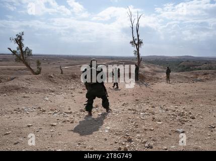 Des soldats d'infanterie israéliens de la 55e brigade de parachutistes armés d'armes légères urinent dans le paysage désertique avant de prendre part à un exercice d'entraînement au tir réel devant la base de Tze'elim dans le sud d'Israël, près de la frontière de la bande de Gaza, le 20 novembre 2023. Les soldats sont tous des troupes de réserve de Tsahal et ne sont pas encore allés dans la bande de Gaza. Certains des soldats sont immédiatement retournés en Israël de l’étranger après l’attaque terroriste du Hamas contre les communautés du Sud d’Israël le 7 octobre 2023. Photo de Jim Hollander/UPI crédit : UPI/Alamy Live News Banque D'Images