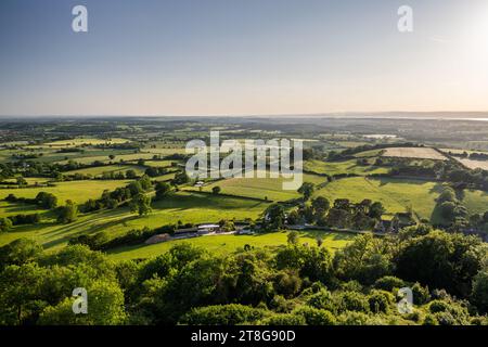 Un patchwork de champs agricoles et de bois remplit le paysage de la vallée de la Severn vue depuis le Cotswolds Edge dans le Gloucestershire. Banque D'Images