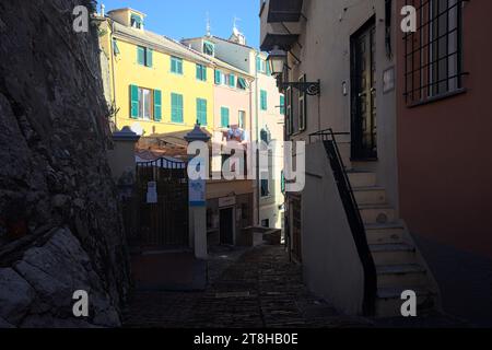 Descente allée étroite entre les bâtiments par une journée ensoleillée dans une ville italienne au bord de la mer Banque D'Images