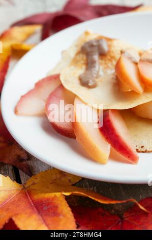 Pommes avec sauce caramel et crêpes aux pois chiches. Banque D'Images