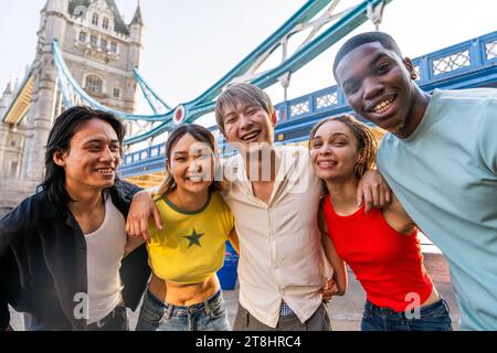 Groupe multiracial de jeunes amis heureux se liant dans la ville de Londres - étudiants adolescents multiethniques se réunissant et s'amusant dans la région de Tower Bridge, Royaume-Uni - concept Banque D'Images