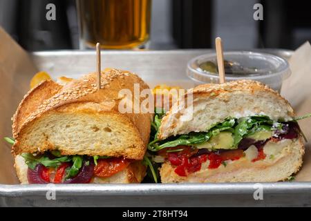 Une image captivante en gros plan d'un sandwich végétarien fraîchement préparé avec un côté de frites servi dans un plateau Banque D'Images