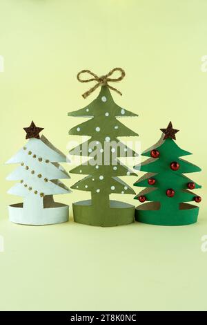 Arbres de Noël créatifs faits à la main en carton sur fond jaune Banque D'Images