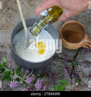 fabrication de bannock, est cuit sur feu ouvert, la farine, la poudre à pâte et l'huile est remuée dans un pot, image de série 2/5 Banque D'Images