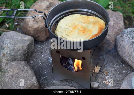 fabrication de bannock, est cuit sur feu ouvert, la pâte à pain est formée et cuite dans une casserole sur un cuiseur de camp, photo de série 5/5 Banque D'Images