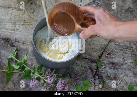 fabrication de bannock, est cuit sur feu ouvert, de l'eau est ajoutée, image de série 3/5 Banque D'Images