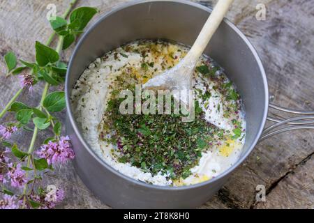 fabrication de bannock, est cuit sur feu ouvert, herbes hachées sont ajoutées, image de série 4/5 Banque D'Images