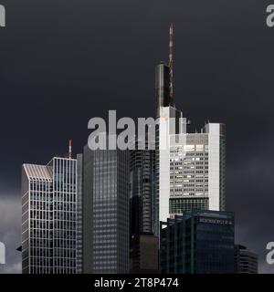 Commerzbank Tower dans la lumière devant des nuages dramatiquement sombres, la lumière et l'ombre dans le quartier bancaire, Francfort-sur-le-main, Hesse, Allemagne Banque D'Images