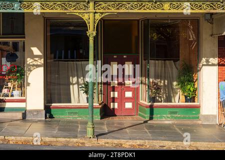 Poteaux de véranda en fer forgé et ornés devant les façades de vieux bâtiments dans un paysage de rue historique à Maldon dans le centre du Victoria, en Australie Banque D'Images