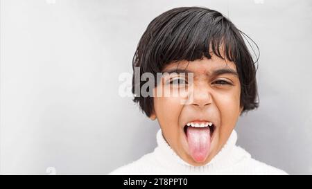 Photo de funky joyeuse joyeuse jeune fille faire visage drôle de bonne humeur isolé sur fond de couleur grise Banque D'Images