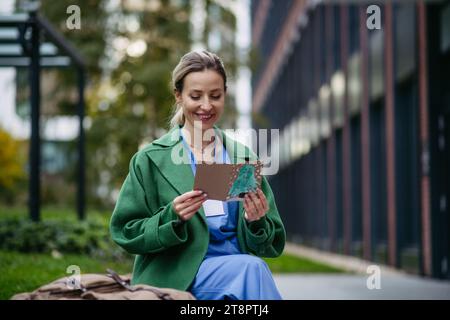 Infirmière lisant la carte de noël d'un enfant malade. Travailler à l'hôpital le jour de Noël. Femme médecin travaillant un quart de travail de Noël et ne peut pas être avec Banque D'Images