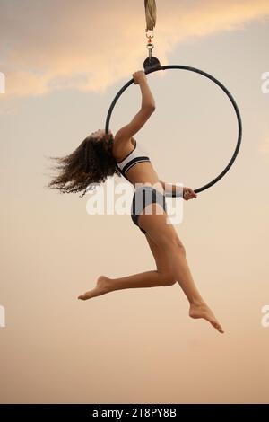 Jeune gymnaste jouant sur le cerceau à l'extérieur Banque D'Images