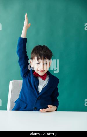 un garçon dans une leçon lève sa classe d'école de main Banque D'Images