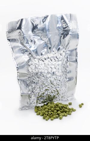 Sac en aluminium avec granulés de houblon aspirés avec un tas de granulés de houblon vert - Žatec, République tchèque Banque D'Images