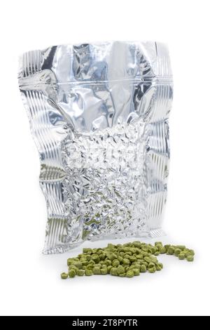 Sac en aluminium avec granulés de houblon aspirés avec un tas de granulés de houblon vert - Žatec, République tchèque Banque D'Images