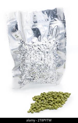 Sac en aluminium avec granulés de houblon aspirés avec un tas de granulés de houblon vert - Žatec, République tchèque Banque D'Images