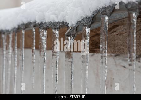 Glaces sur le toit. Le drain est plein de neige et de glace. Icicles tomber danger concept. Banque D'Images