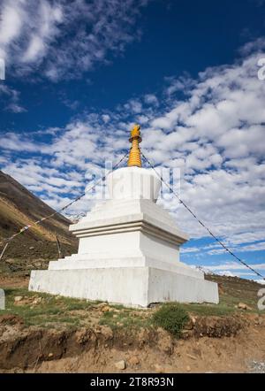 Un Stupa bouddhiste ou Chorten isolé dans la montagne avec des nuages vibrants dans le ciel Banque D'Images