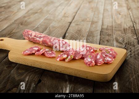 Salami italien tranché sur une planche à découper. Banque D'Images