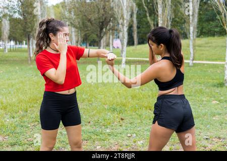 Deux jeunes boxeuses féminines s'entraînant en plein air. Entraînement de boxe et de poinçonnage. Banque D'Images