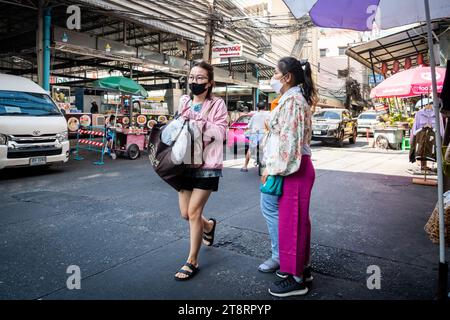 Une jeune femme thaïlandaise fait son chemin à travers le marché de Pratunam pour faire ses courses. Banque D'Images