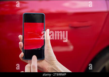 Gros plan du conducteur prenant la photo des dommages à la voiture après un accident sur le téléphone portable Banque D'Images